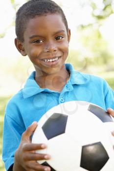 Young African American Boy Holding Football In Park