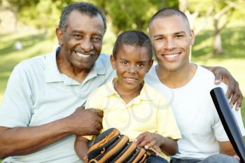 African American Grandfather, Father And Son Playing Baseball In Park