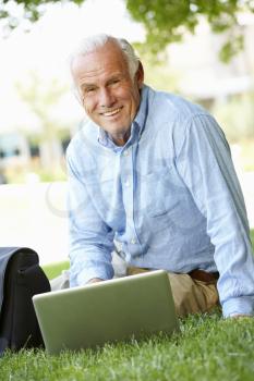 Senior man using laptop outdoors