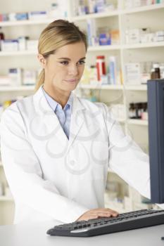 Pharmacist working on computer in pharmacy