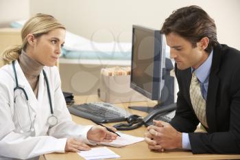 Doctor talking to businessman patient