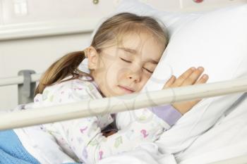 Young girl asleep in hospital bed