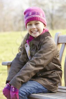 Portrait young girl sitting outdoors in winter