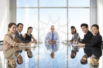Group Of Business People Having Board Meeting Around Glass Table
