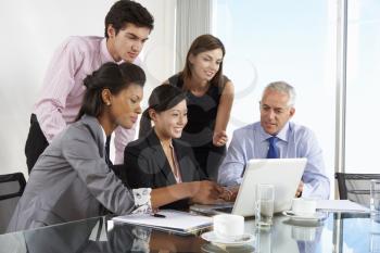 Group Of Business People Having Meeting Around Laptop At Glass Table