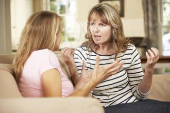 Mother And Teenage Daughter Arguing On Sofa At Home