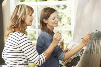 Female Artist Teaching Pupil In Studio