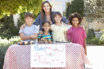 Group Of Children Holding Bake Sale With Mother