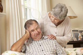 Senior Woman Comforting Unhappy Husband At Home