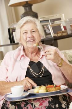 Senior Woman Enjoying Meal At Home