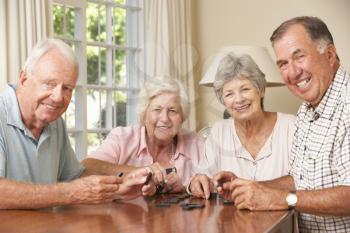 Group Of Senior Couples Enjoying Game Of Dominoes At Home