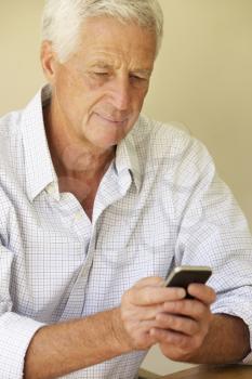 Senior Man Sending Text Message Sitting On Sofa