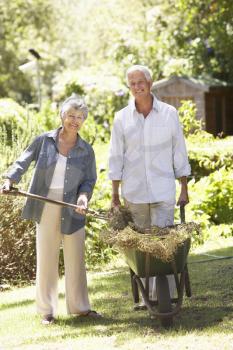 Senior Couple Working In Garden At Home