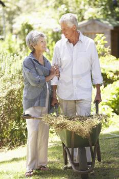 Senior Couple Working In Garden At Home