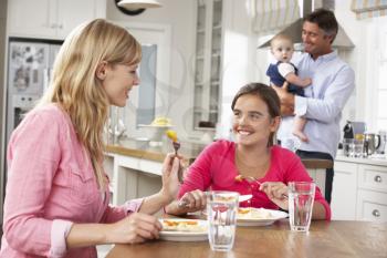 Family Having Meal In Kitchen Together