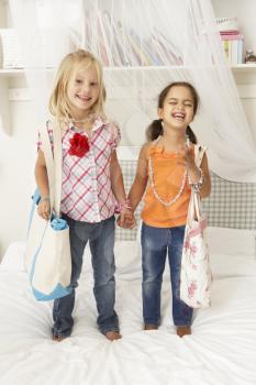 Two Young Girls Dressing Up Together In Bedroom