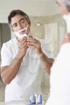 Man Shaving In Bathroom Mirror