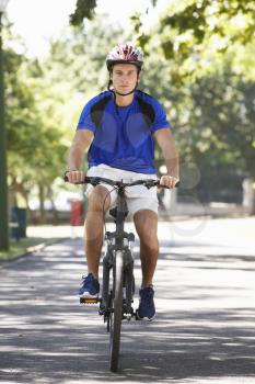 Young Man Cycling Through Park