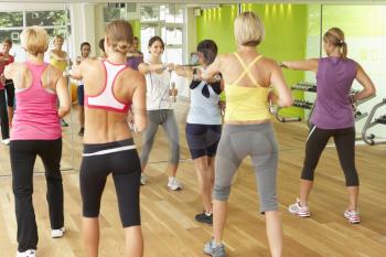 Women Taking Part In Gym Fitness Class Using Weights