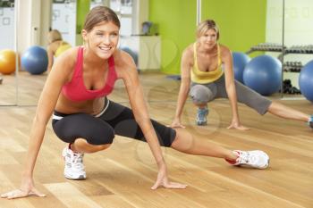 Two Women Taking Part In Gym Fitness Class
