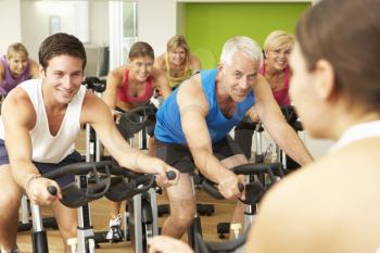 Group Taking Part In Spinning Class In Gym