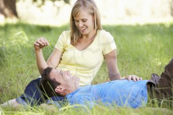 Couple Relaxing In Sunny Summer Field