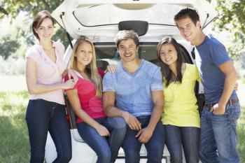 Group Of Young Friends Sitting In Trunk Of Car