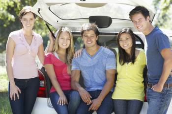 Group Of Young Friends Sitting In Trunk Of Car