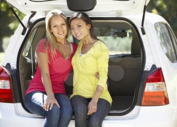 Two Young Women Sitting In Trunk Of Car