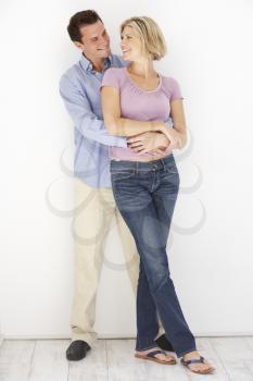 Studio Portrait Of Romantic Couple Embracing Against White Background
