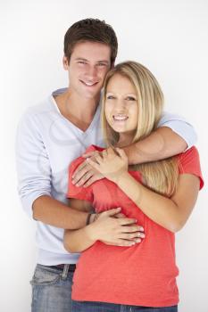 Studio Portrait Of Romantic Young Couple Embracing Against White Background