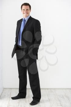 Studio Portrait Of Businessman Standing Against White Background