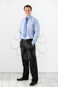 Studio Portrait Of Businessman Standing Against White Background