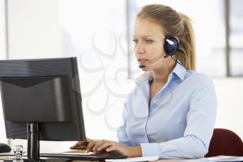 Friendly Service Agent Talking To Customer In Call Centre