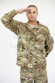 Studio Portrait Of Soldier Wearing Uniform And Saluting