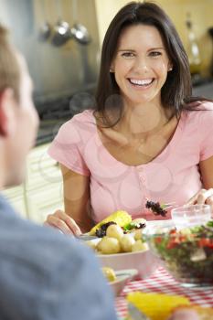 Couple Eating Meal Together In Kitchen