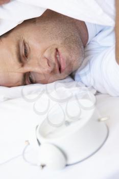 Grumpy Man In Bed Turning Off Alarm Clock