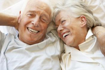 Senior Couple Relaxing In Bed
