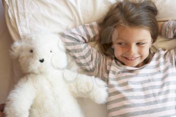 Young Girl Relaxing In Bed With Toy