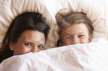 Mother And Daughter Hiding Under Bedclothes