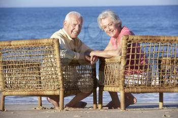 Senior Couple Sitting In Chairs Relaxing On Beach