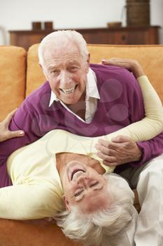 Romantic Senior Couple Lying On Sofa At Home