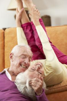 Romantic Senior Couple Lying On Sofa At Home