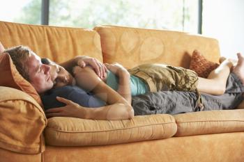Romantic Couple Lying On Sofa At Home