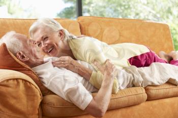 Senior Couple Lying On Sofa At Home