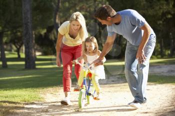 Parents Teaching Daughter To Ride Bike