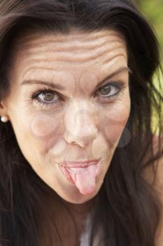 Head And Shoulders Portrait Of Woman Sticking Out Tongue