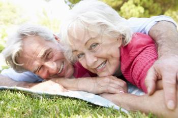 Senior Couple Relaxing In Park Together