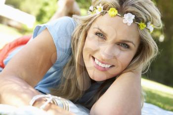 Woman Lying In Park Wearing Flowers Around Hair