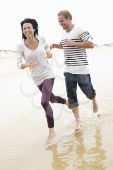 Couple Running Along Beach Together